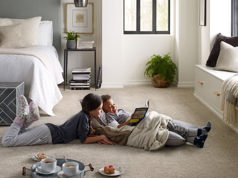 two people reading on a carpet bedroom floor - USA Carpets in GA